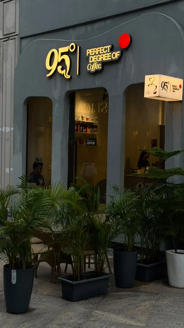 The 95 Degree storefront behind the potted palms