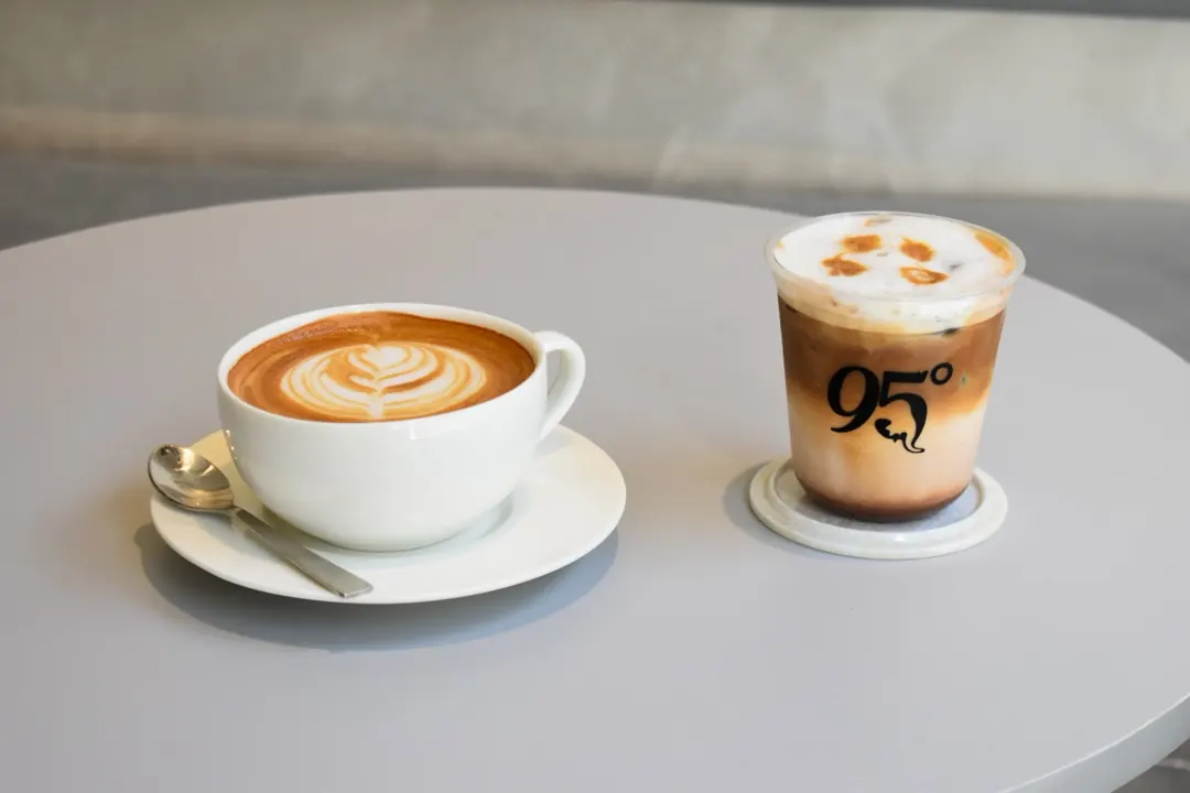 A hot latte and an iced latte on a table