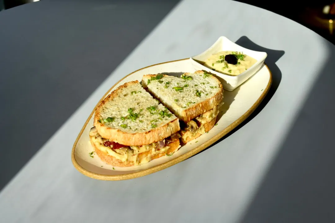 A sourdough sandwich with a dip in the sun